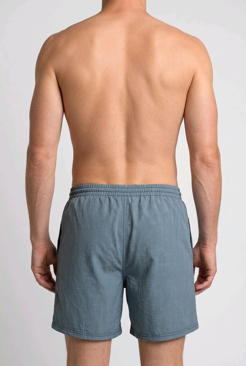 Man wearing blue swim shorts back view