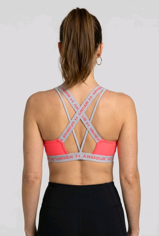 Women wearing a Under Armour pink sports bra back view