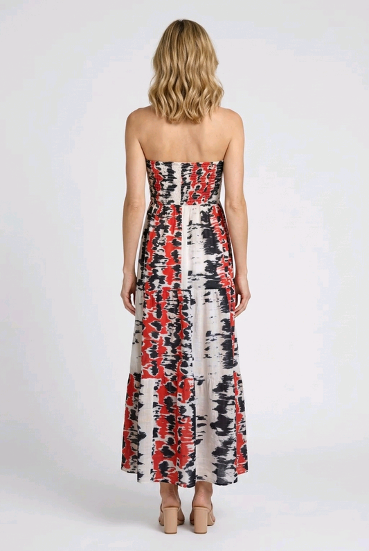 Woman wearing a strapless dress with red and black abstract pattern