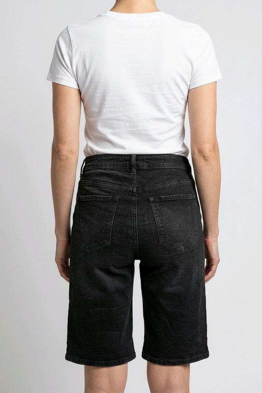 Woman wearing a white t-shirt and black denim shorts