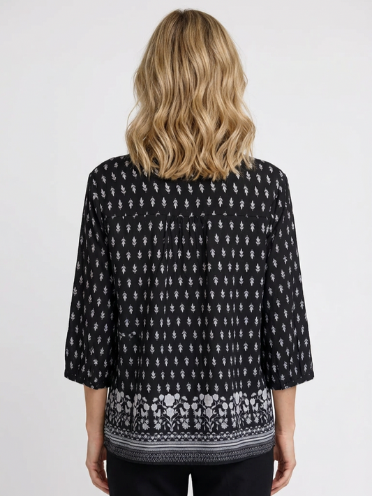 Person wearing a black patterned blouse