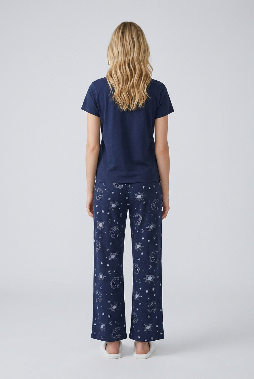 Woman wearing navy blue pajama set with celestial pattern on pants