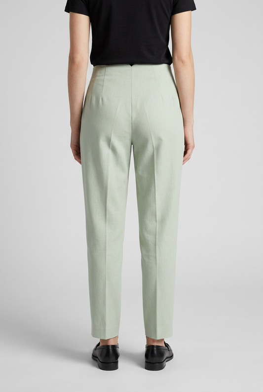 Woman wearing light green trousers and black shoes