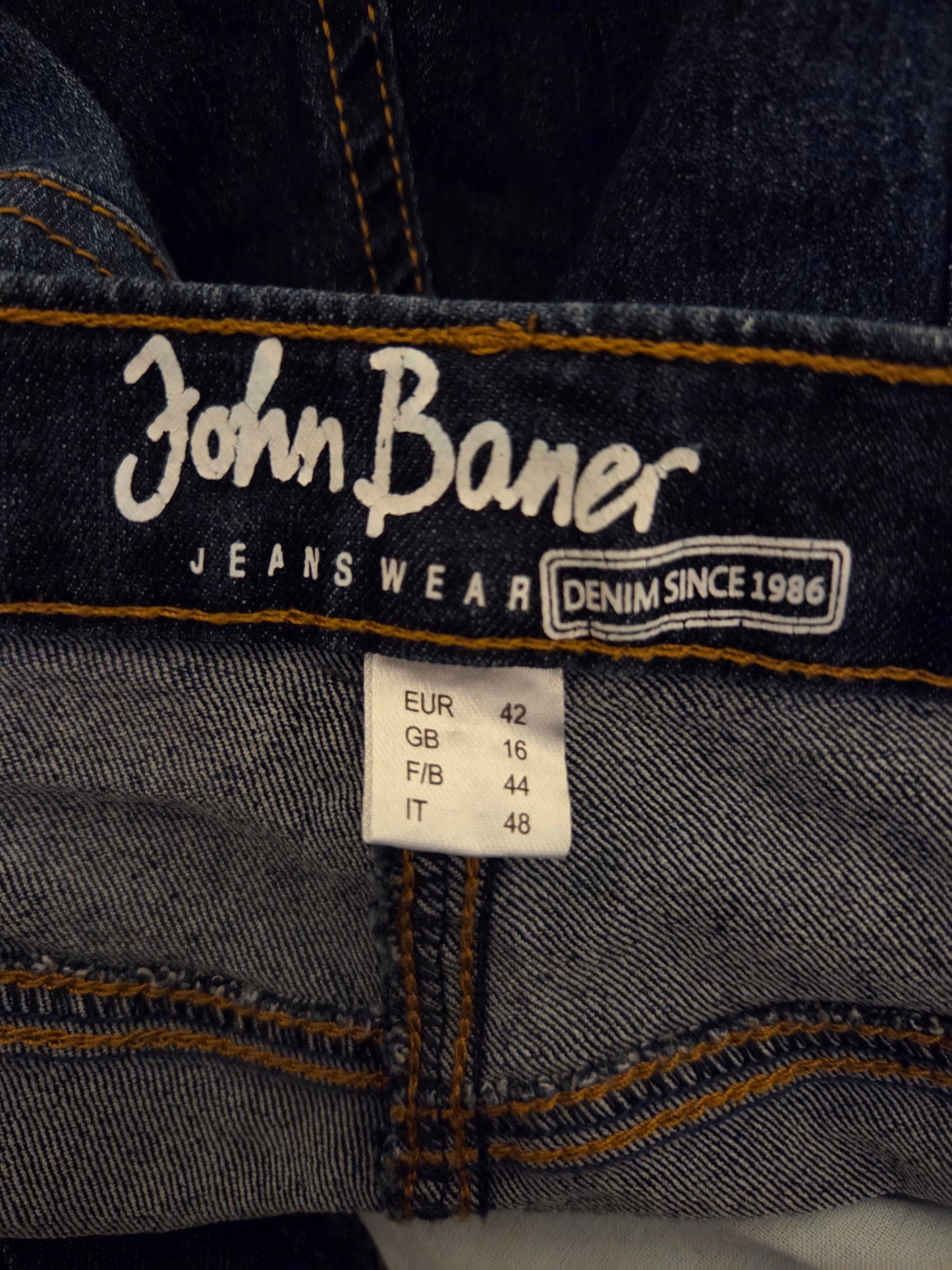 Close-up of John Baner jeans with brand name and size label.