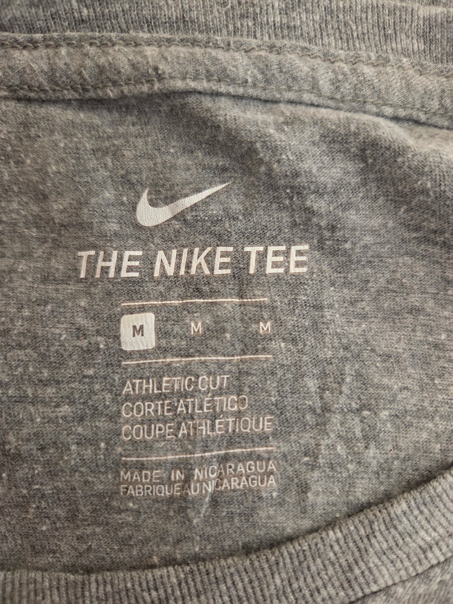 Gray Nike sweatshirt with brand logo and text on a textured fabric background