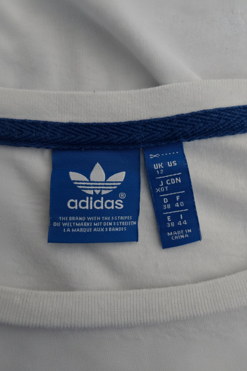 Close-up of Adidas label on a beige garment with blue accents.