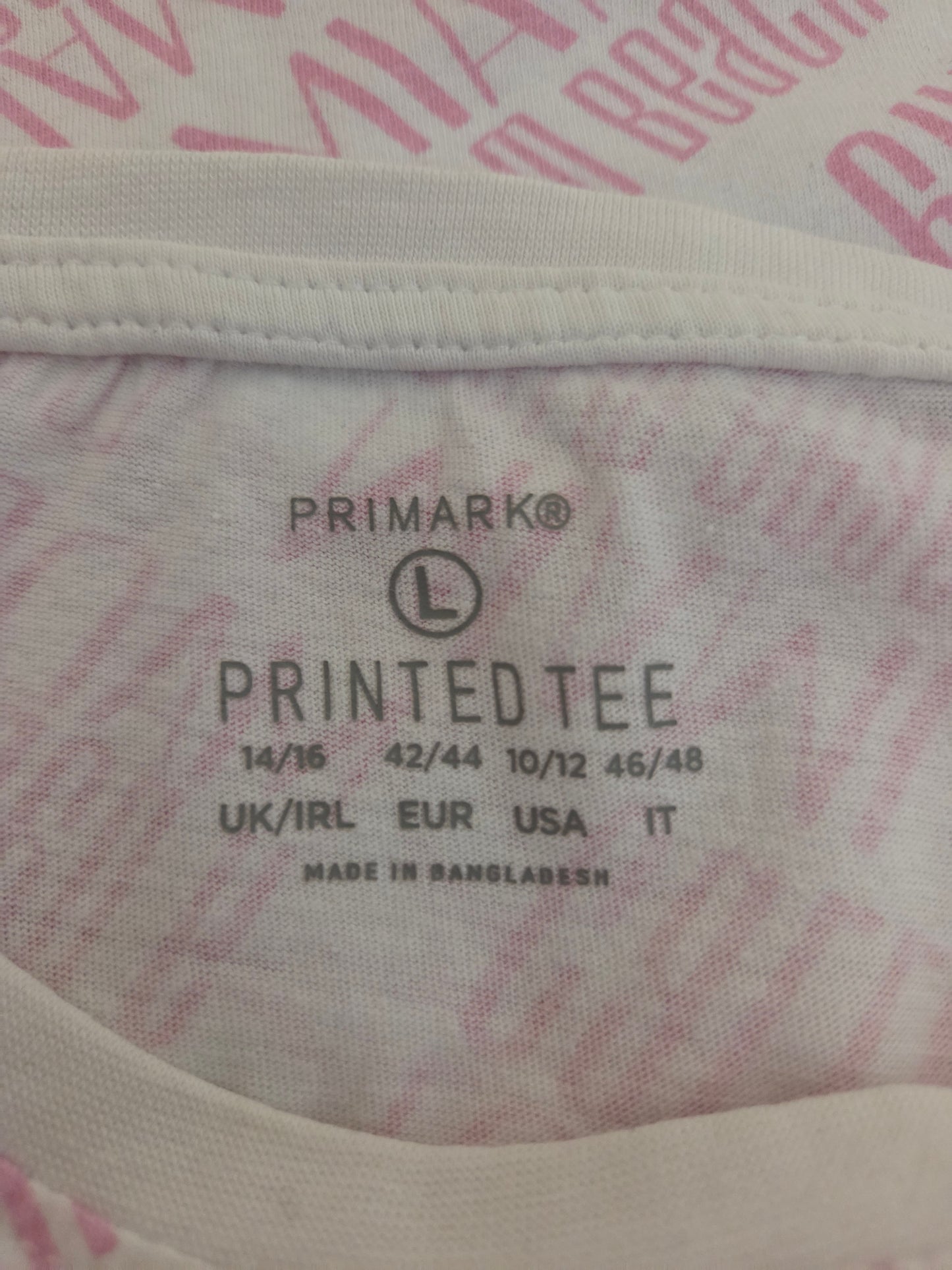 Close-up of a Primark printed tee size label on fabric.