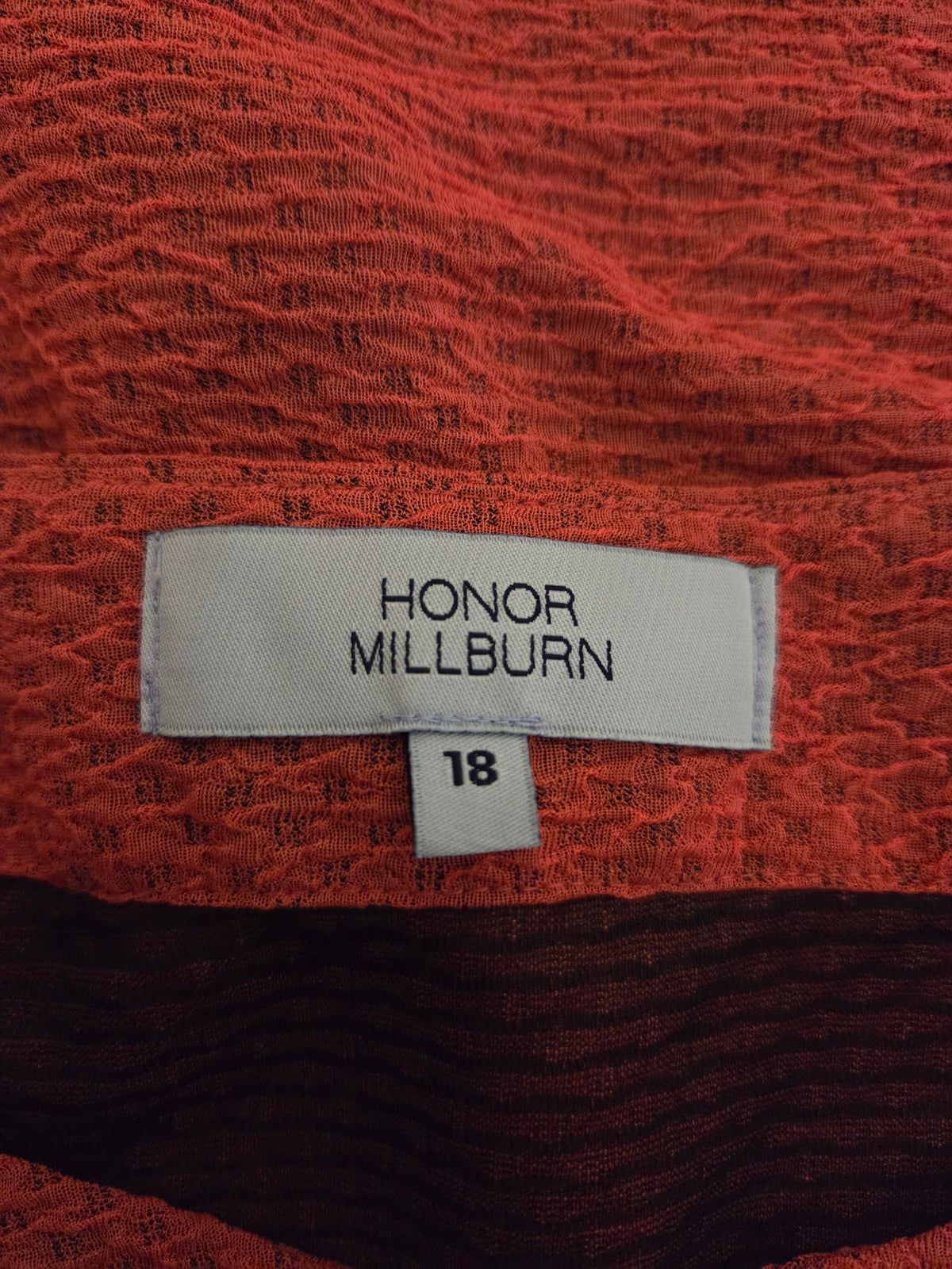 Fabric texture with a 'Honor Millburn' label on a red background