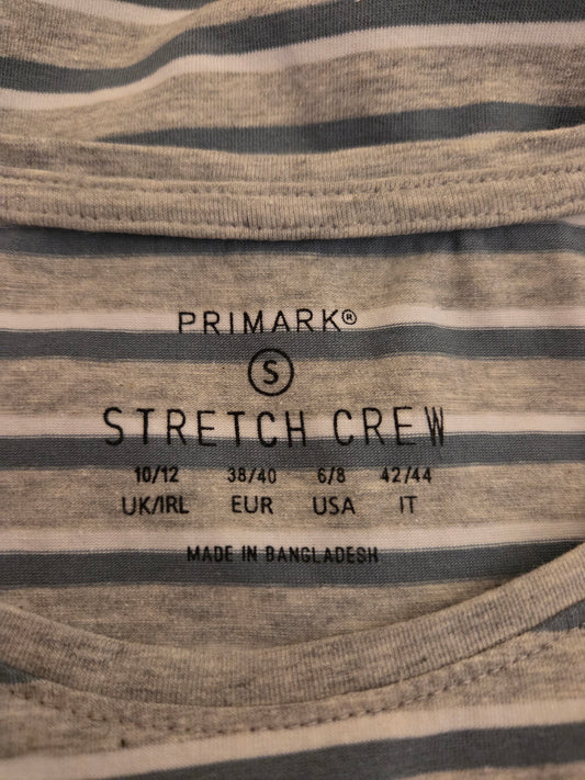 Close-up of a Primark stretch crew label on striped fabric.