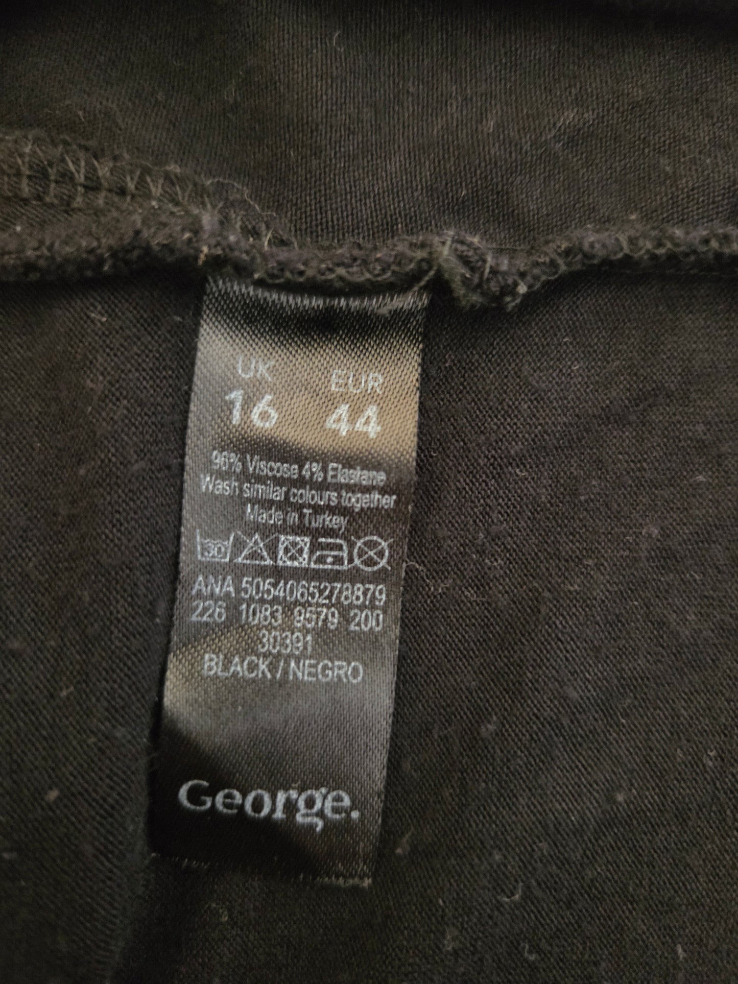 Clothing label on a dark fabric with brand name 'George'.