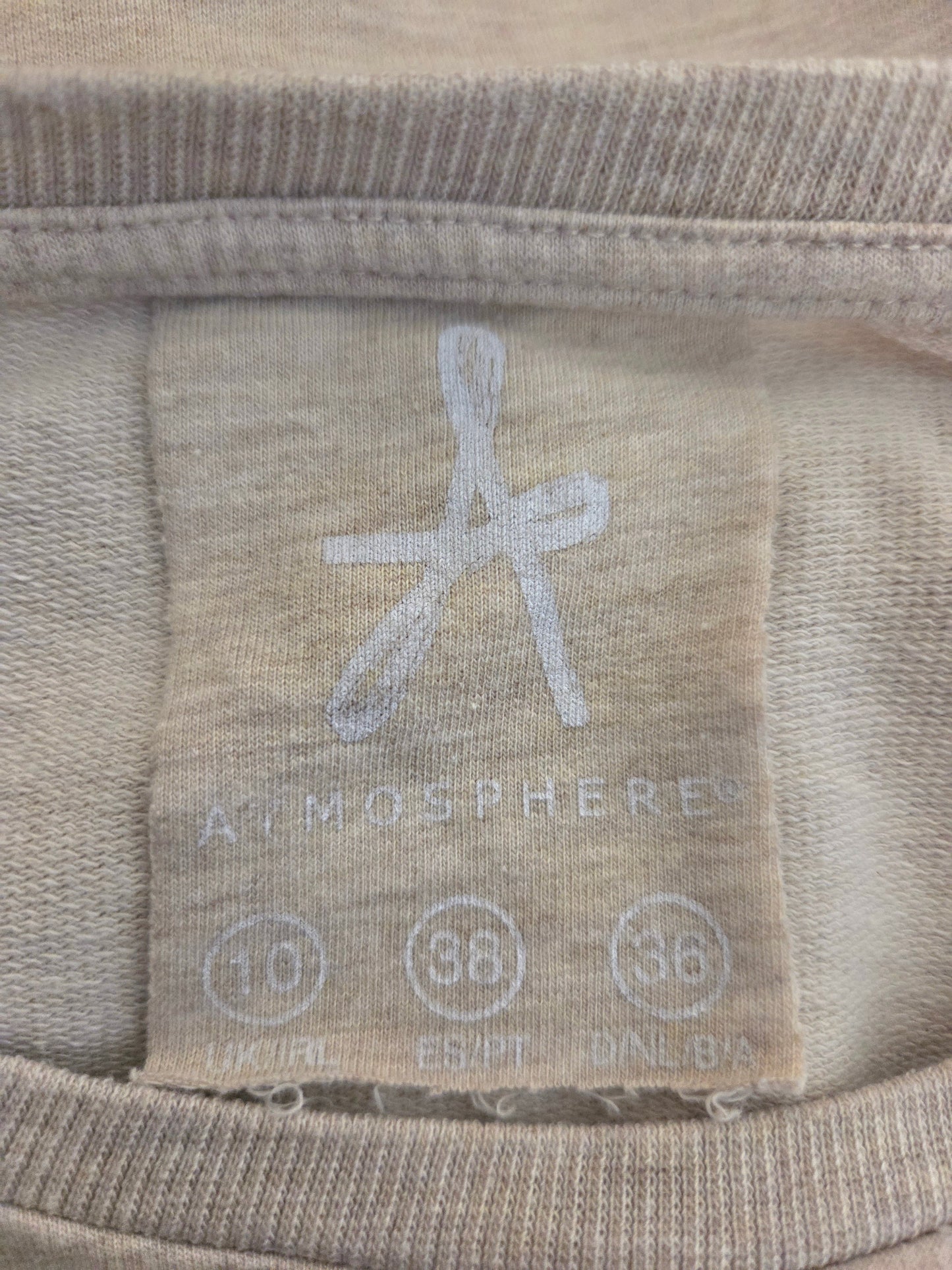 Close-up of a fabric label with 'Atmosphere' branding on a beige background