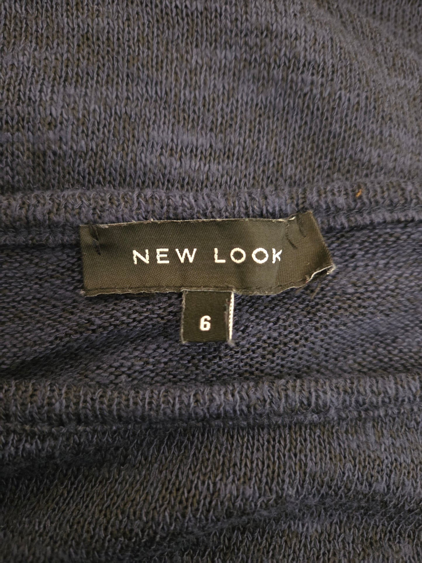 Close-up of a 'New Look' size label on a textured fabric background