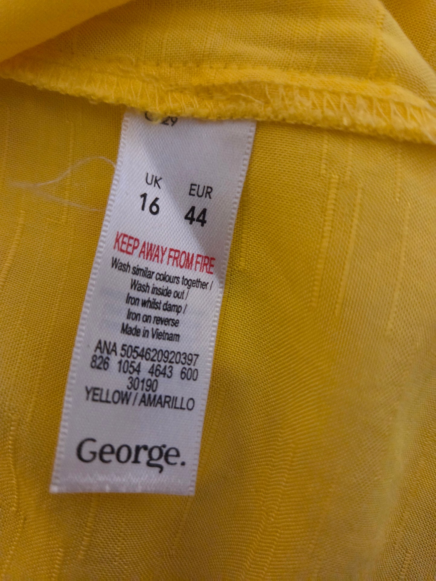 Close-up of a george size label on a yellow fabric background