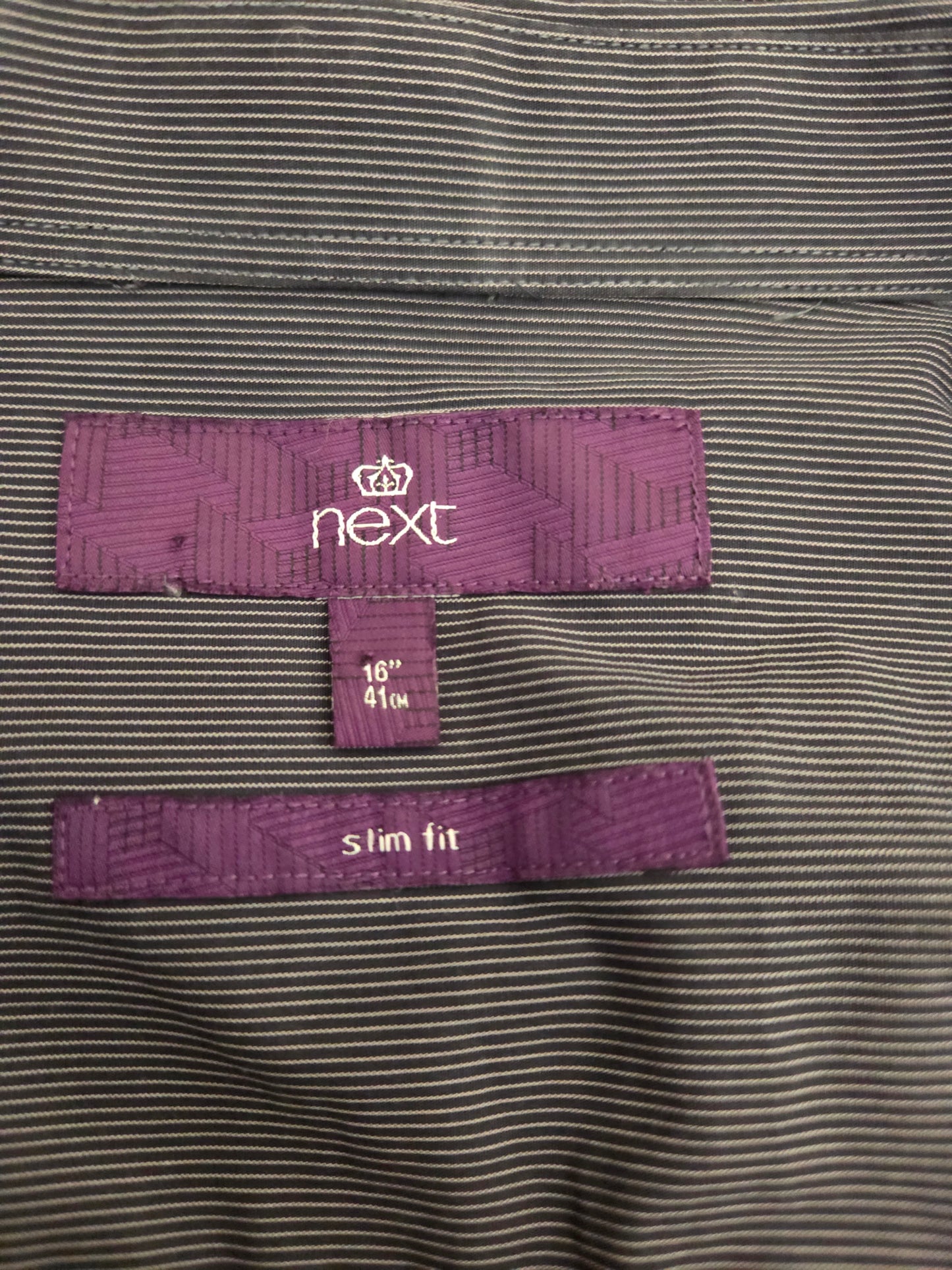Close-up of striped fabric and purple label inside shirt