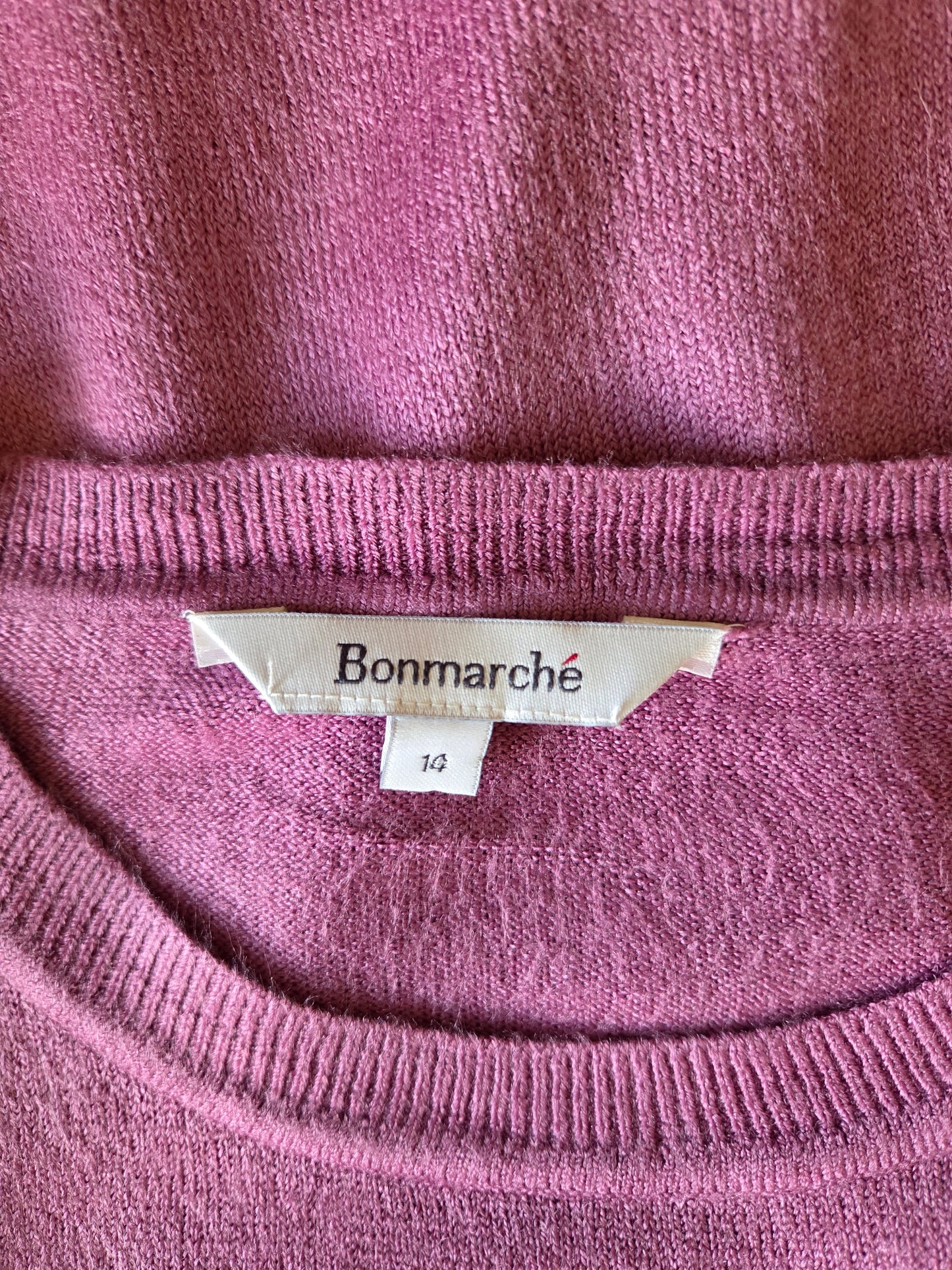 Close-up of a purple sweater with a Bonmarché size label.
