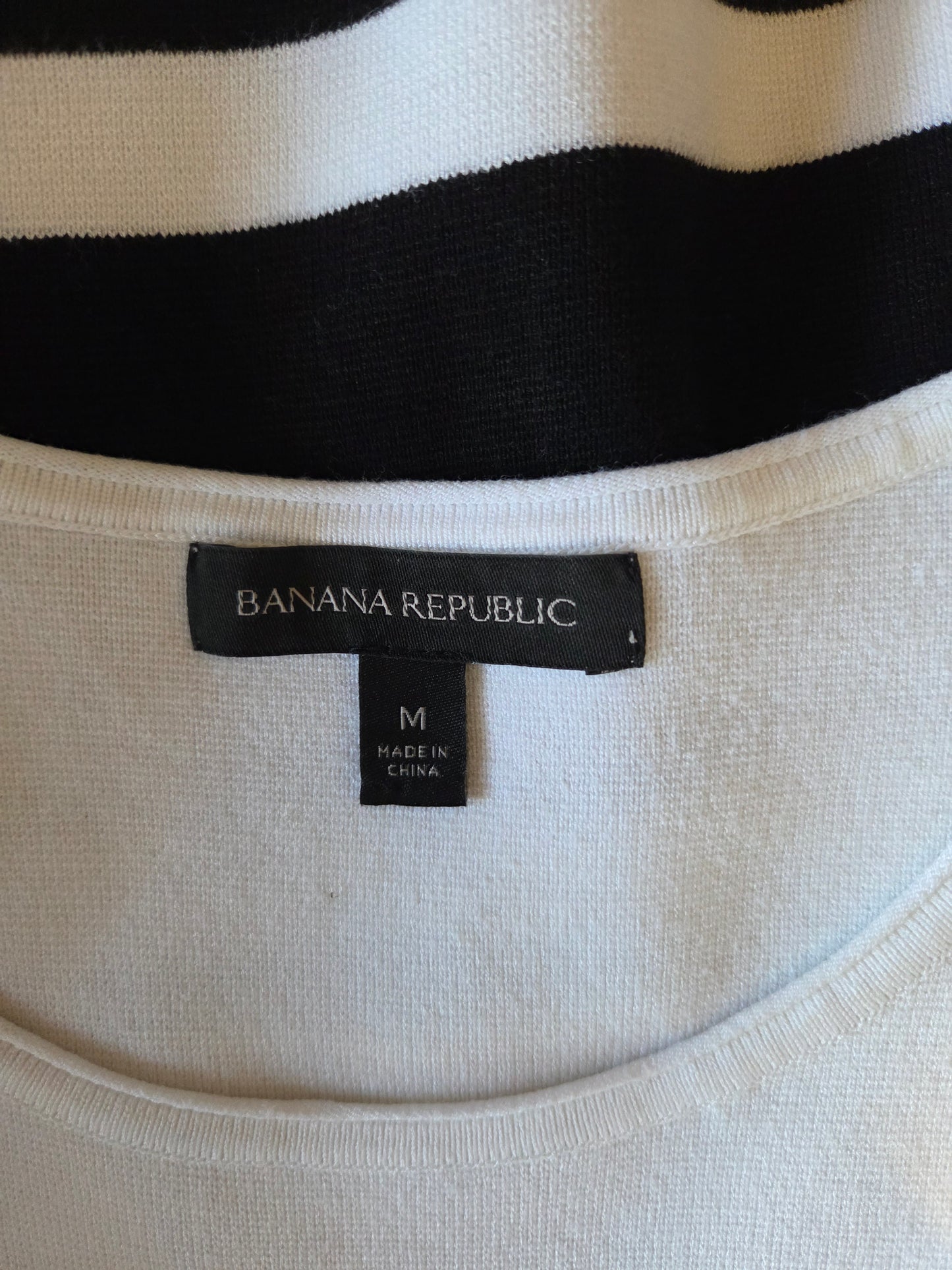 Close-up of a Banana Republic label on a garment with black and white stripes.