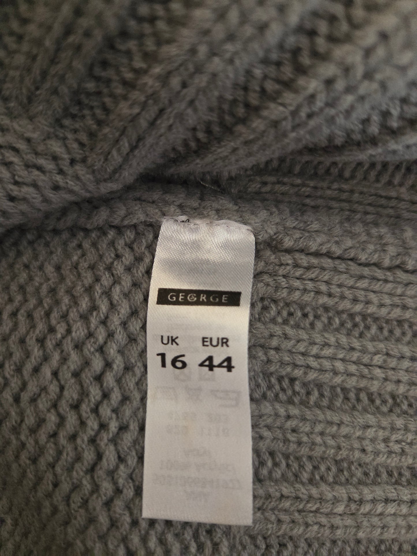 Close-up of a grey textured fabric with a size tag