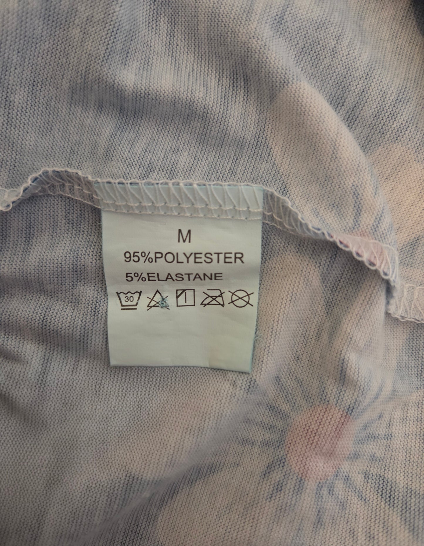 Fabric with a label indicating 95% polyester and 5% elastane on a textured background.