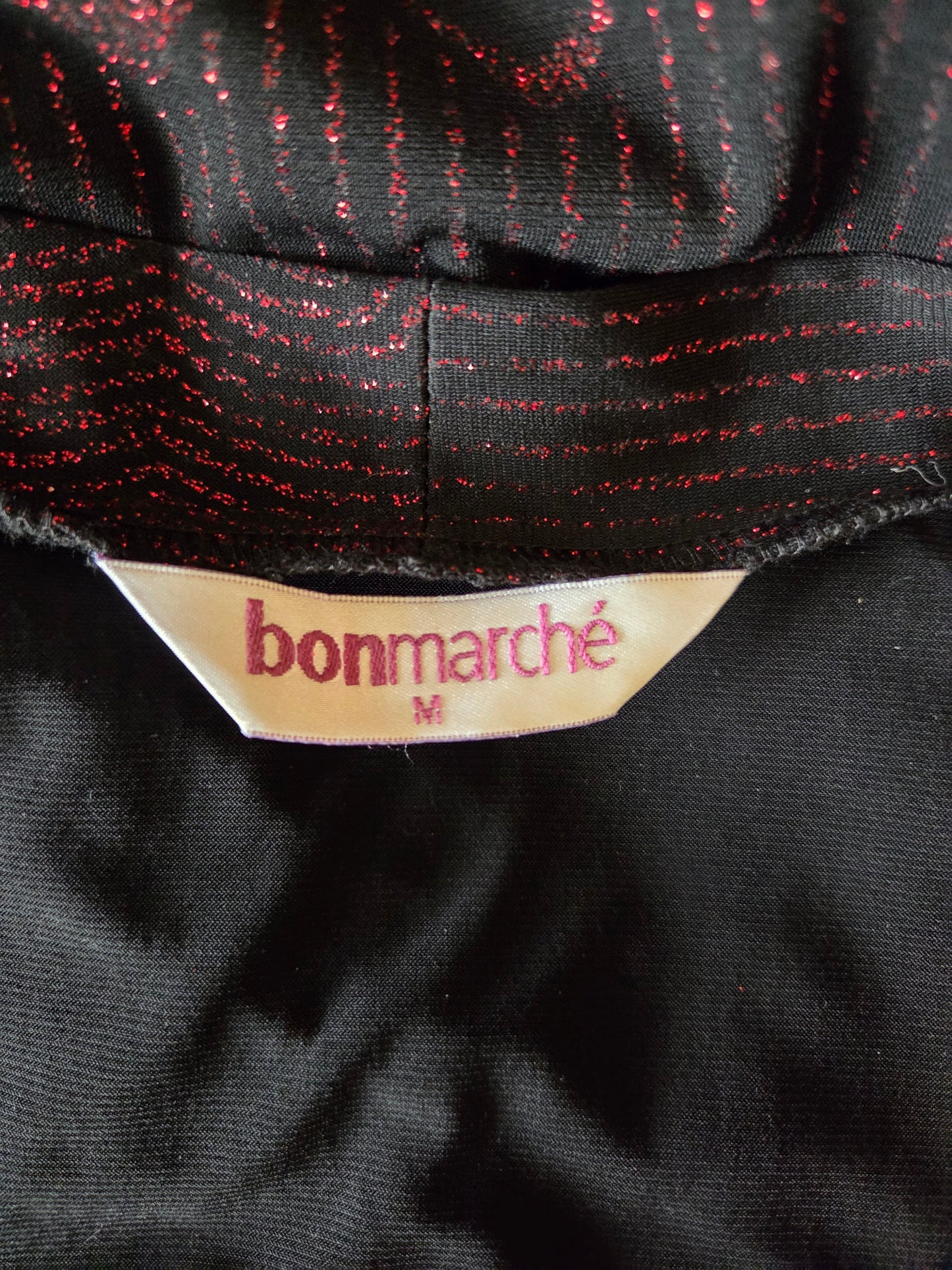 Close-up of a black fabric with red thread and a 'bonmarché' label.