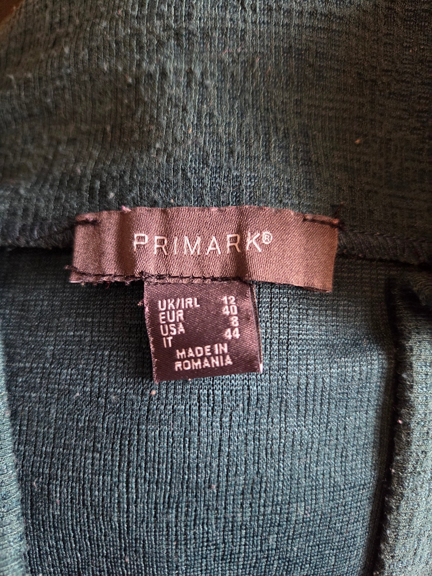 Close-up of a Primark label on a dark fabric background