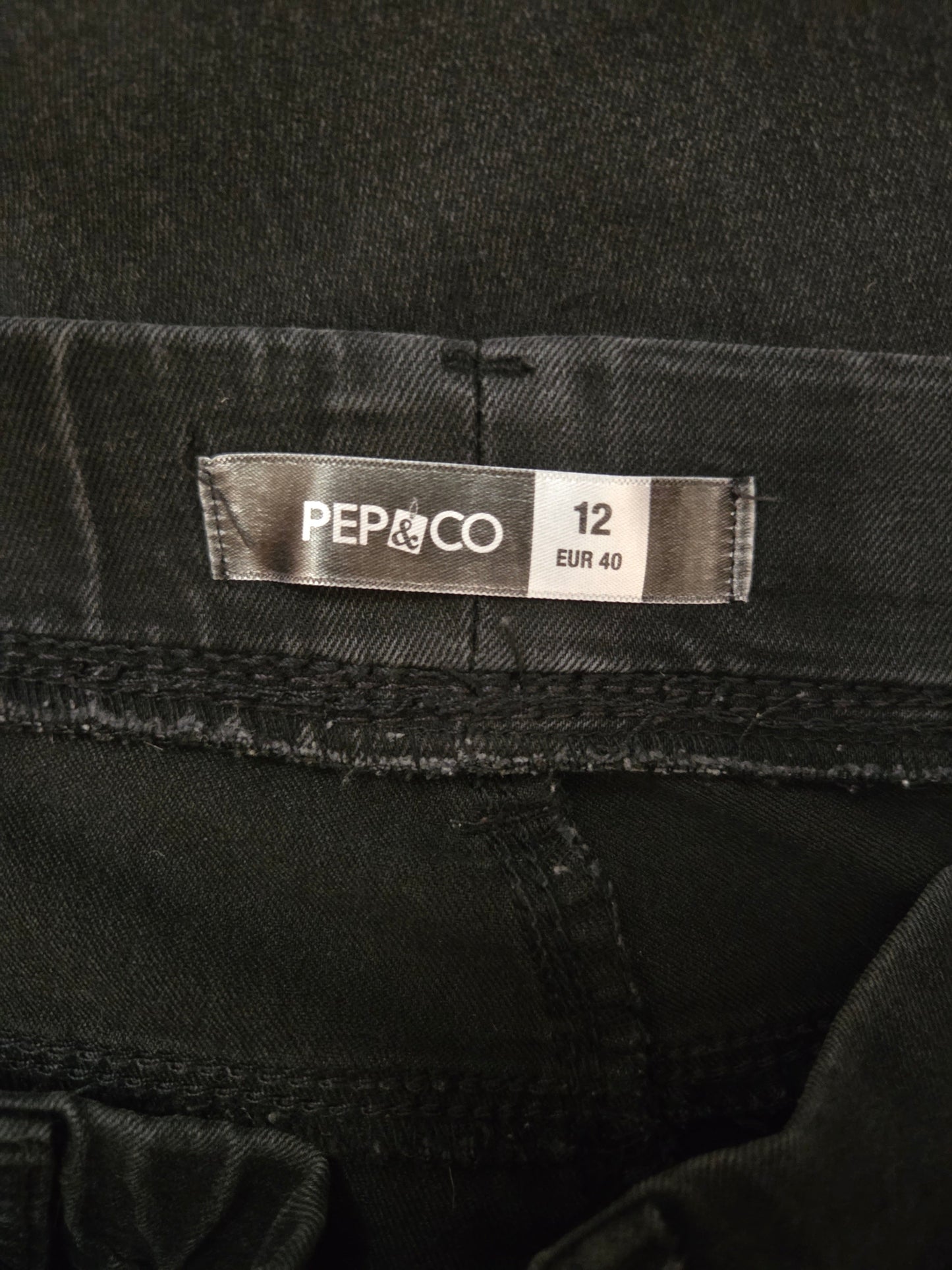 Black denim fabric with a 'Pep & Co' label showing size 12.