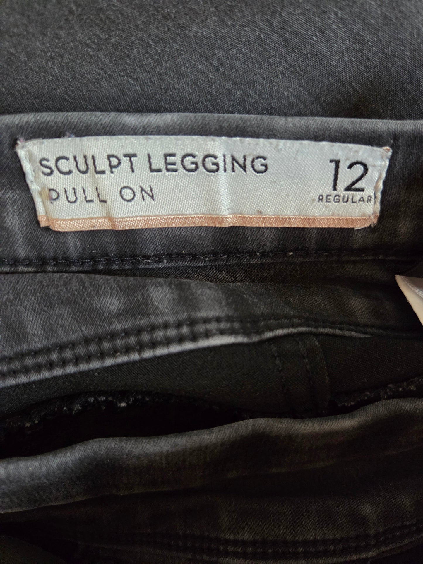black leggings with a size label on a dark background