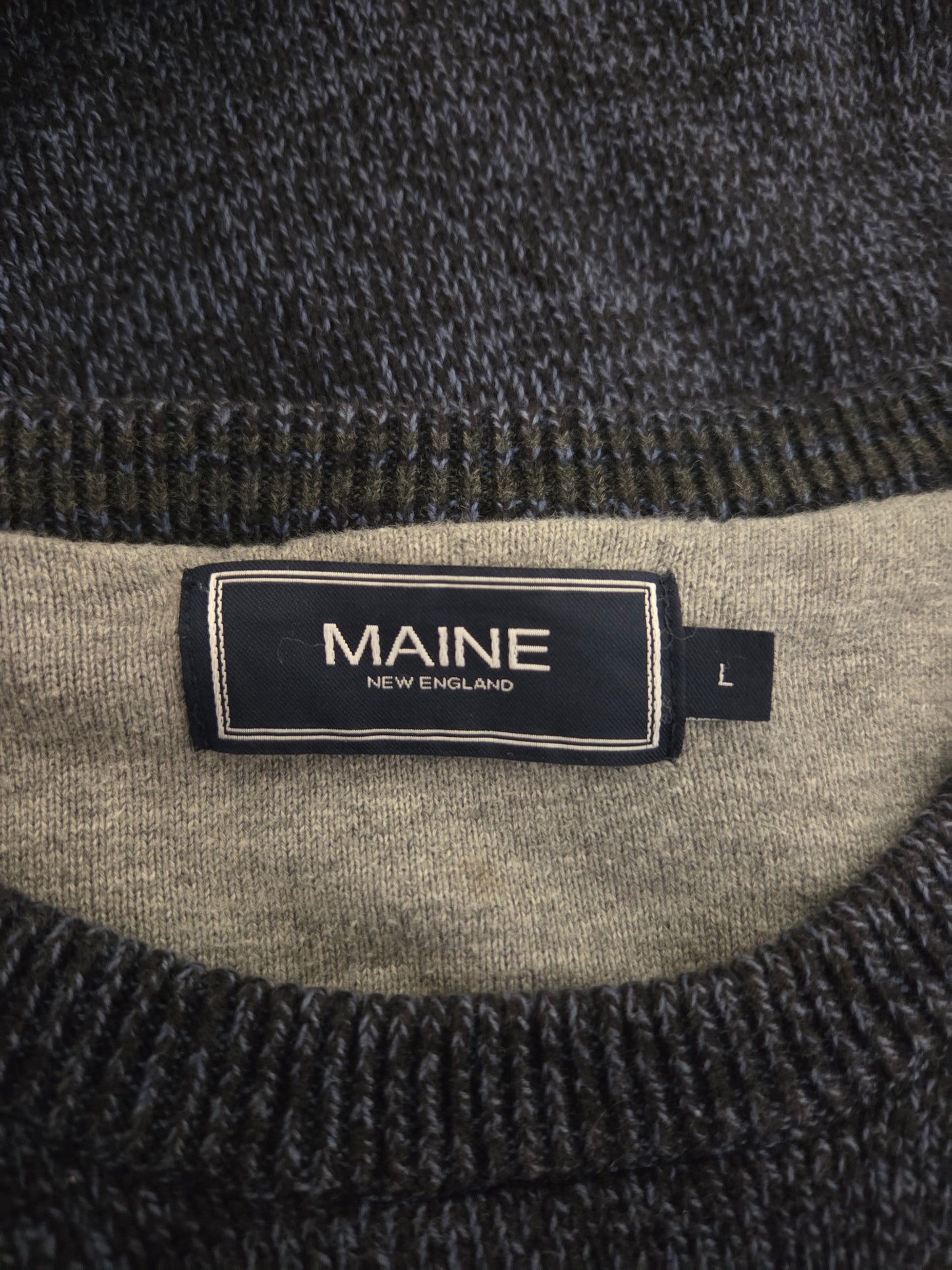 Close-up of a label on a textured fabric with 'MAINE' text.