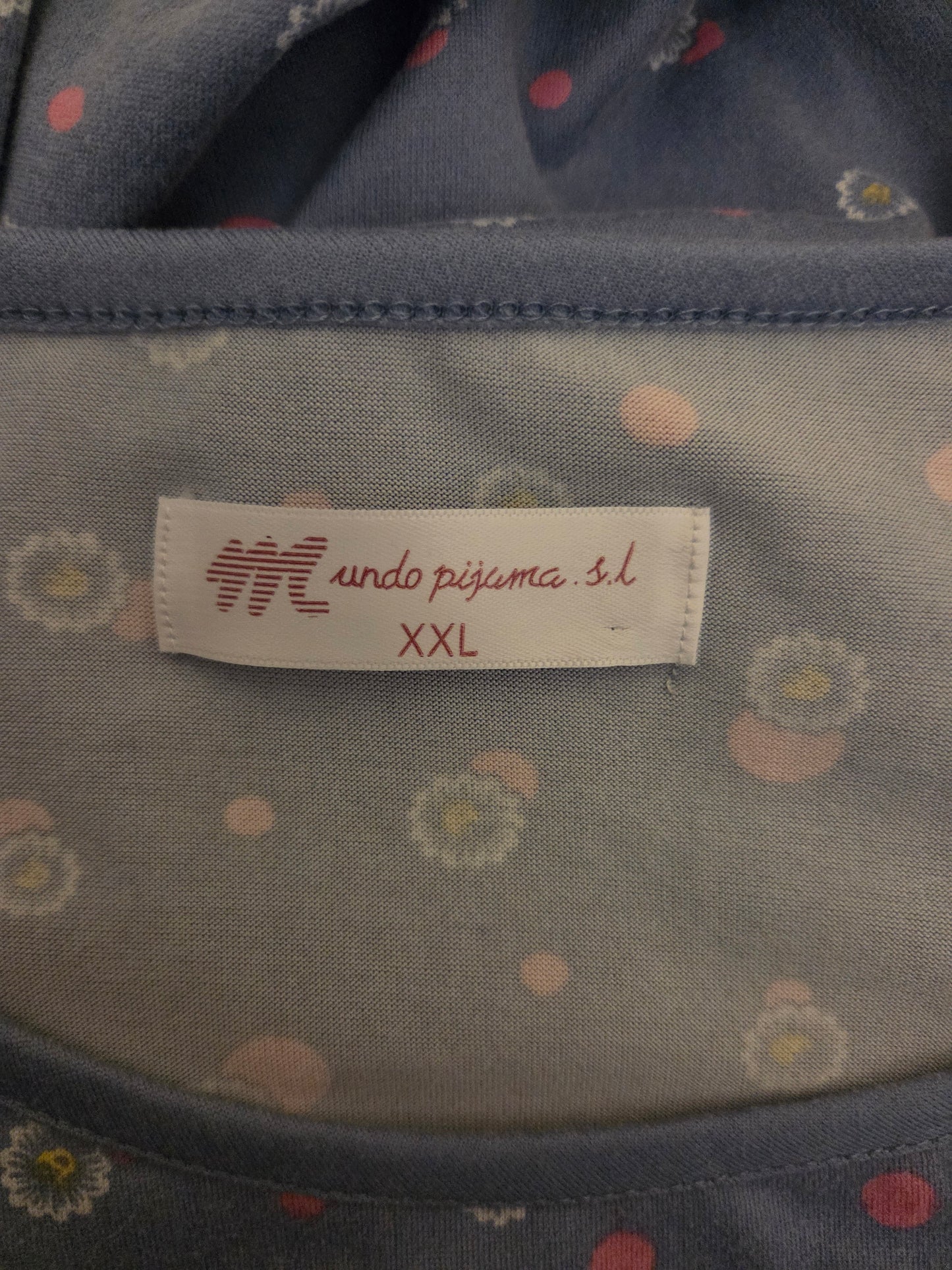 Fabric with a label on a garment, featuring a brand logo and text.