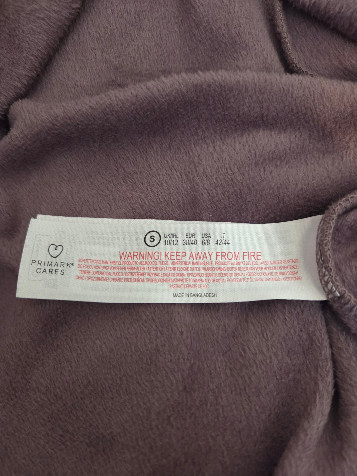 Close-up of a size label on a purple fabric surface
