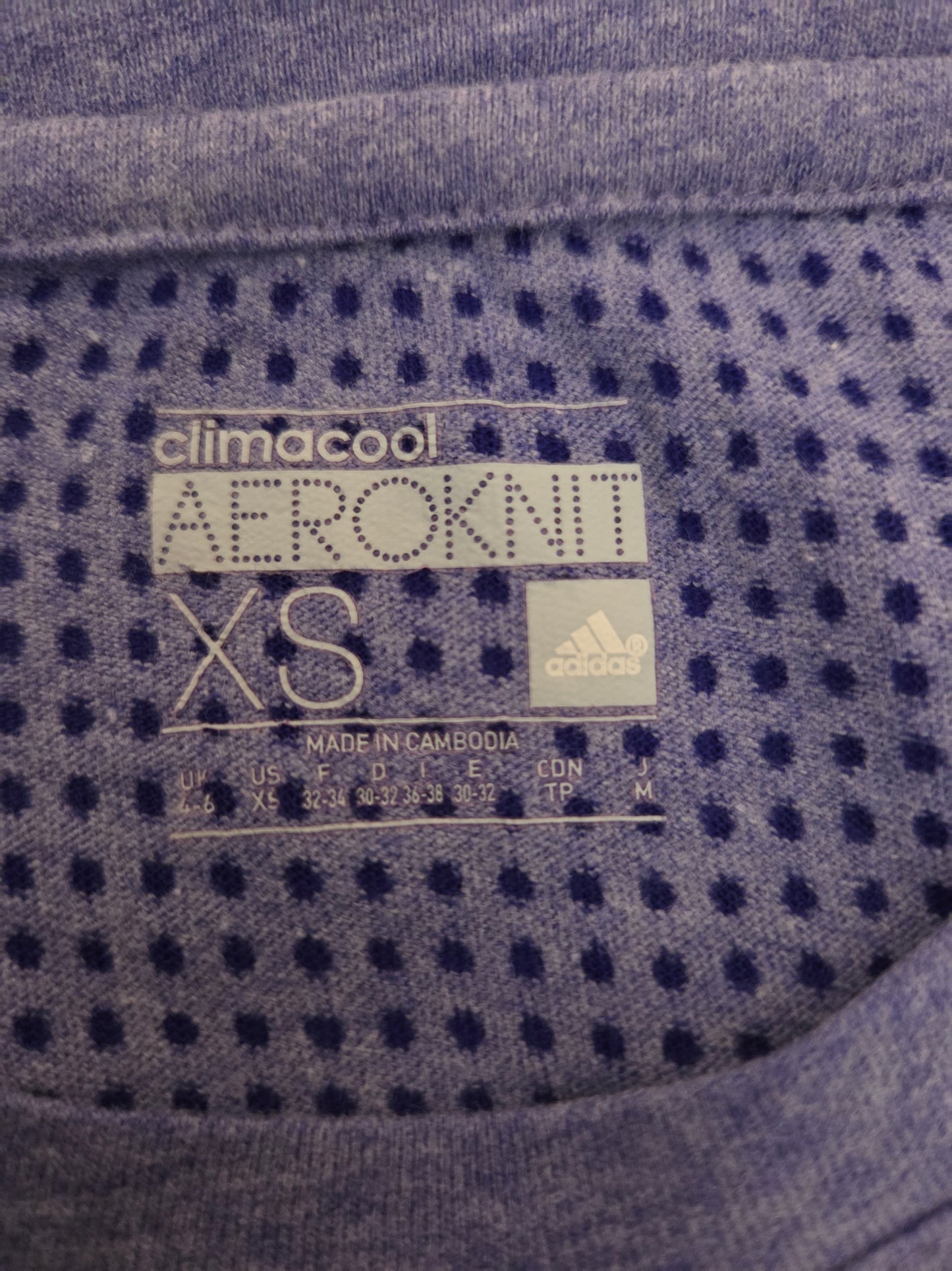Close-up of Adidas climacool Aeroknit XS label on a textured fabric background