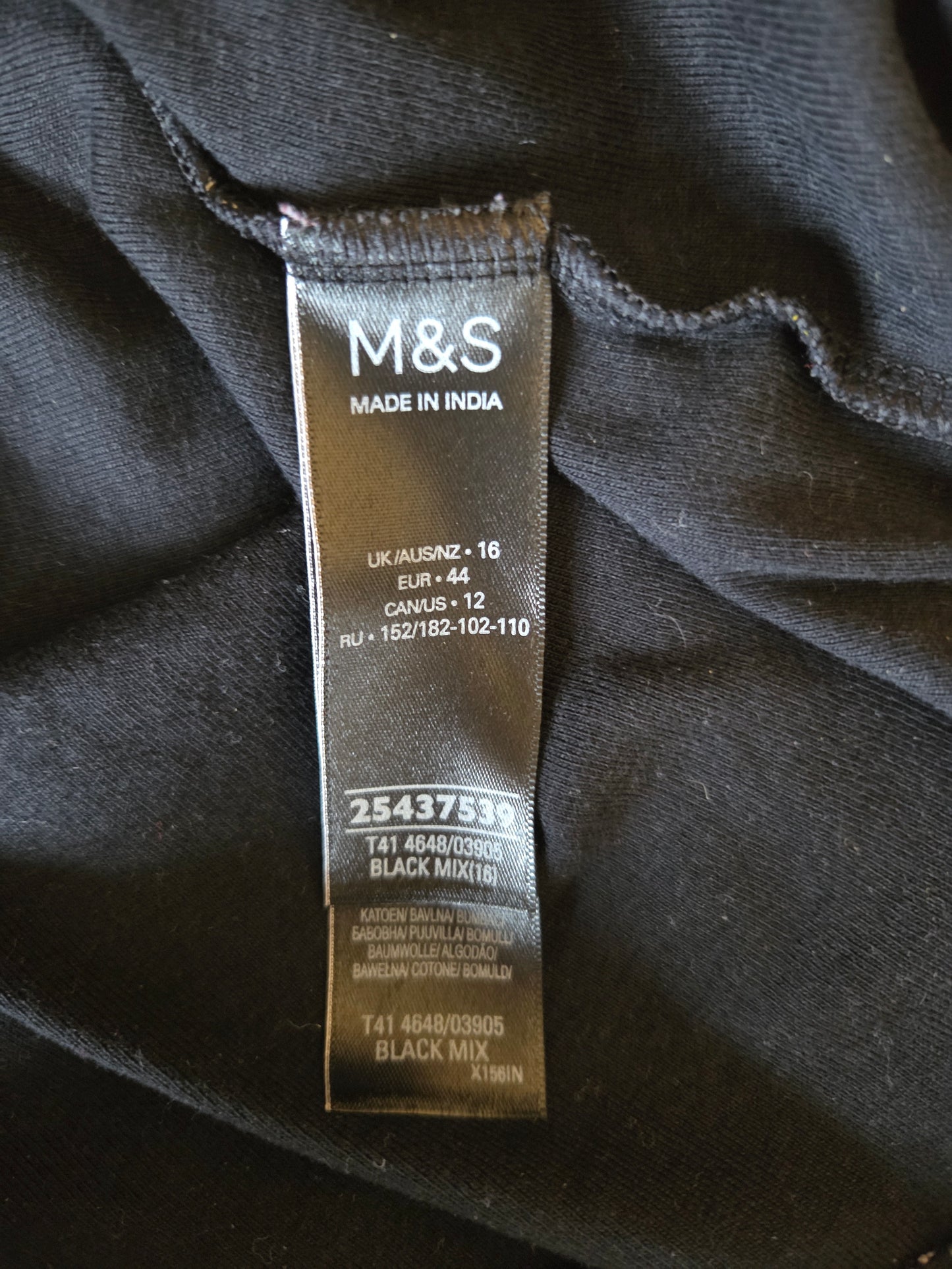 M&S size label on a dark fabric background