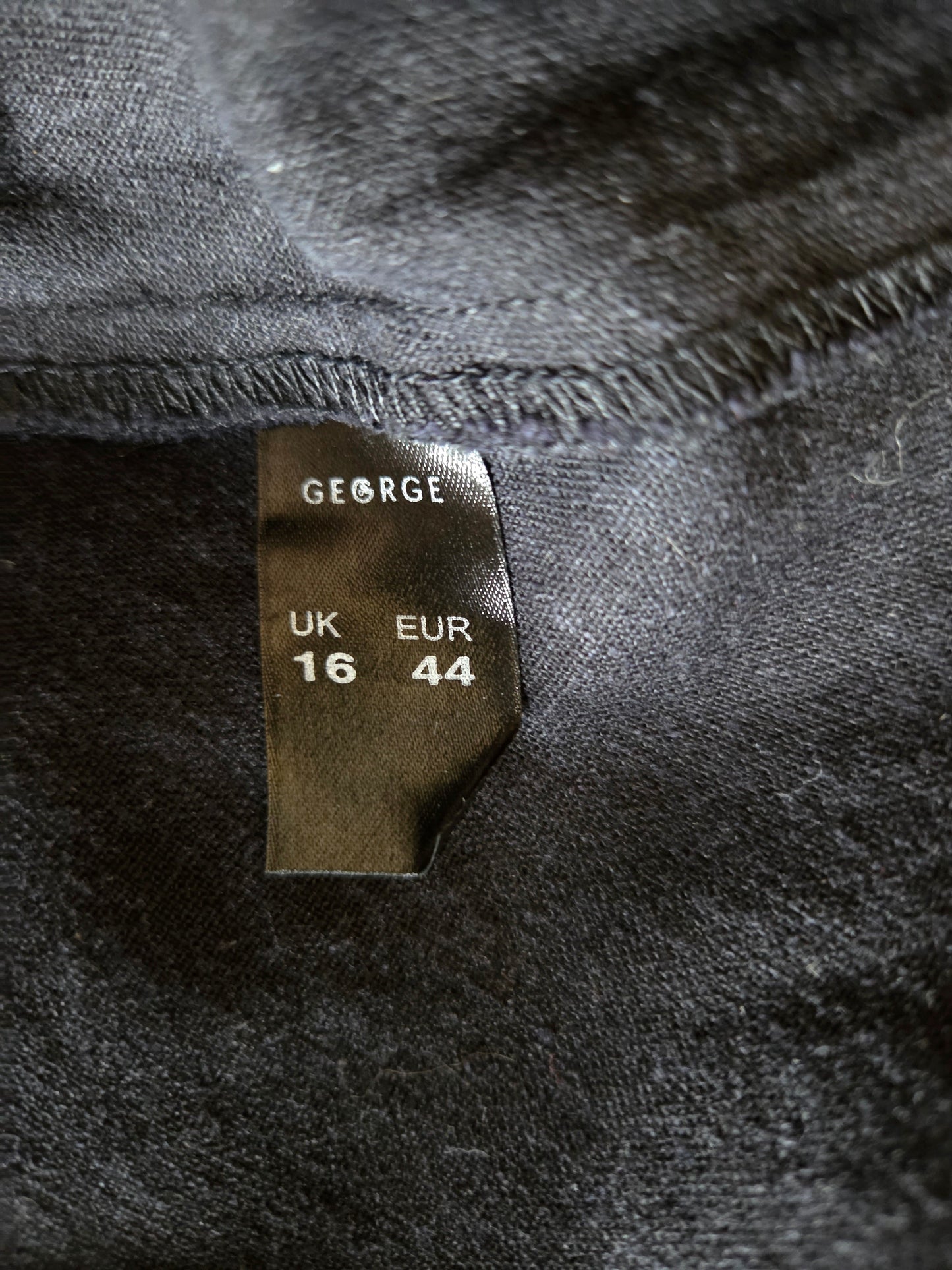 Size tag on a dark fabric with brand name 'GEORGE'.