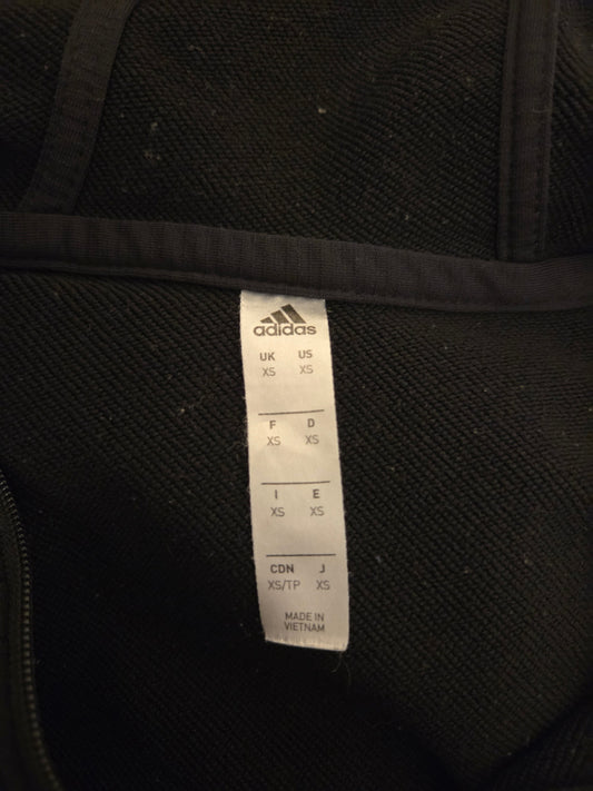 Black Adidas garment with a label on a black background