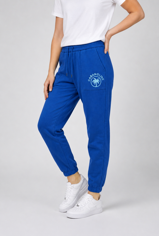 Person wearing blue jogger joggers with a logo side view