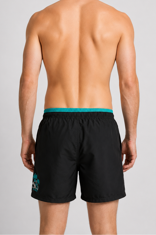 Man wearing black swim shorts with a green waistband