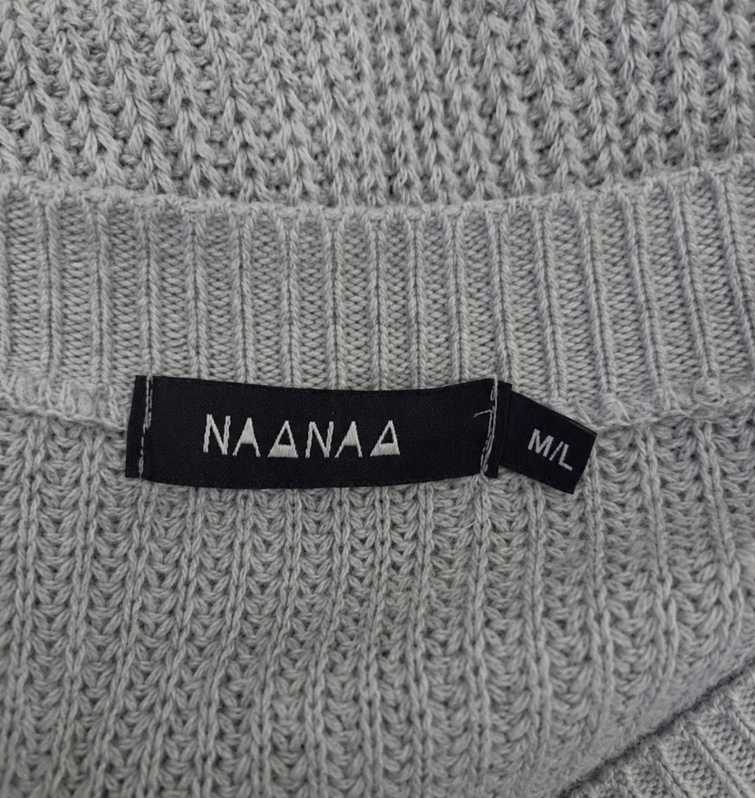 Grey knit fabric with a brand size label on a textured background