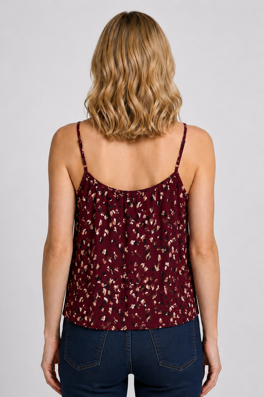 Woman wearing a maroon floral camisole and dark blue