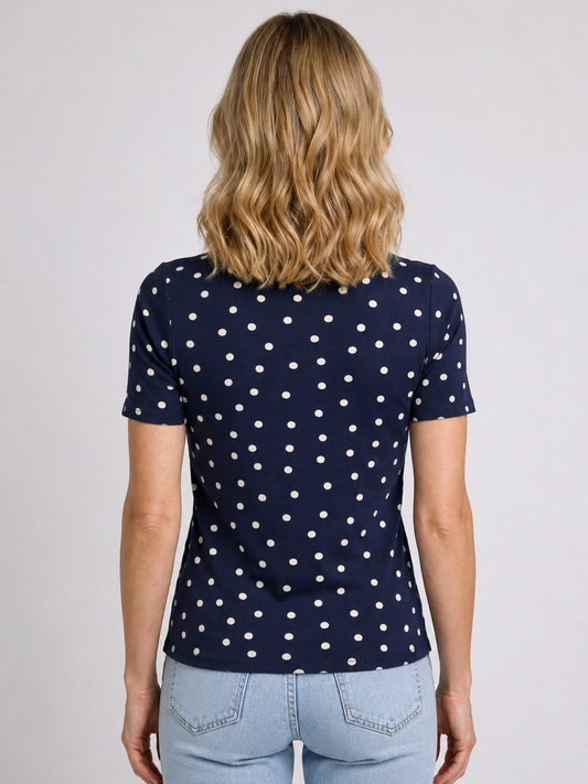 Woman wearing a navy blue polka dot top with light blue jeans