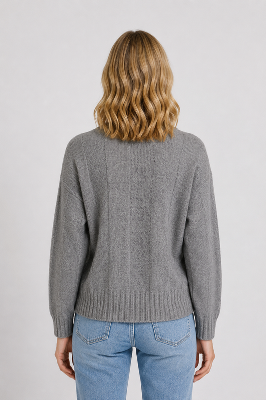 Woman wearing a grey sweater and blue jeans