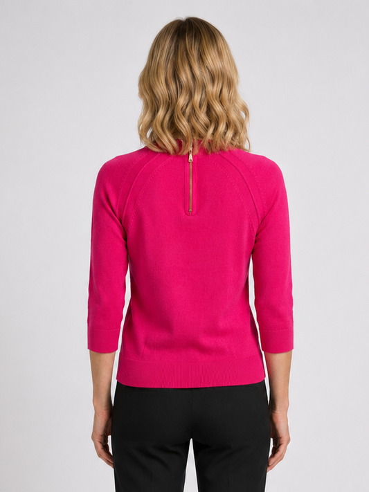 Person wearing a bright pink long-sleeve top with a zip