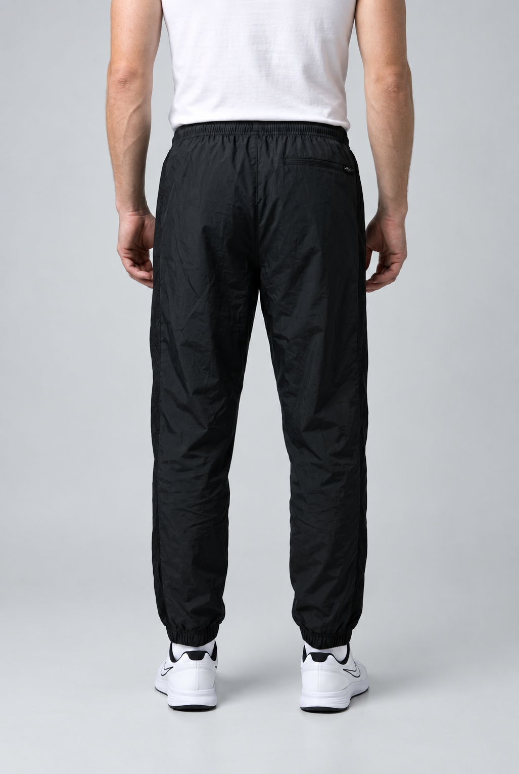 Man wearing black Nike tracksuit bottoms size L back view