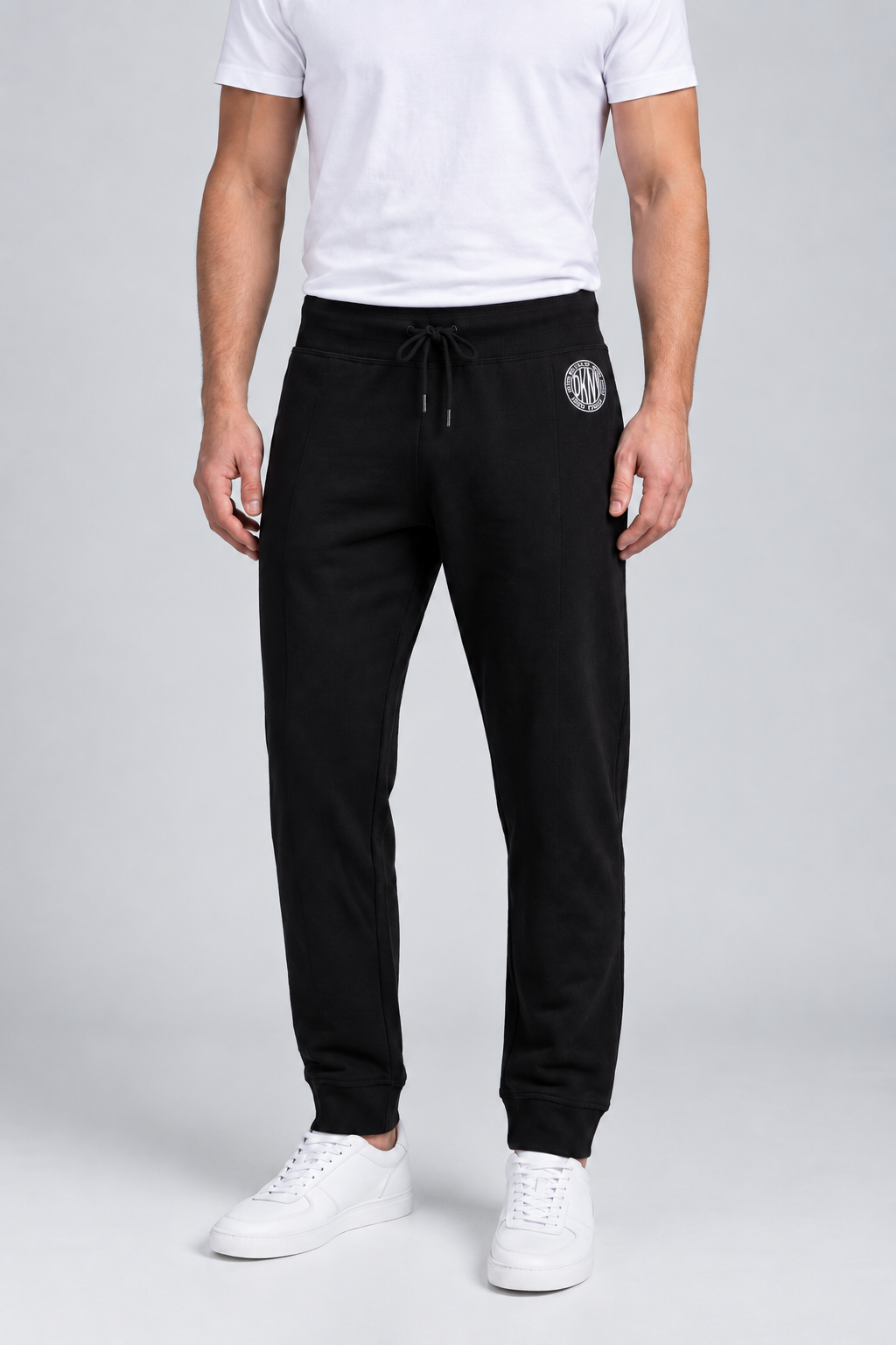 Close up of a man wearing a pair of black DKNY joggers size M front view