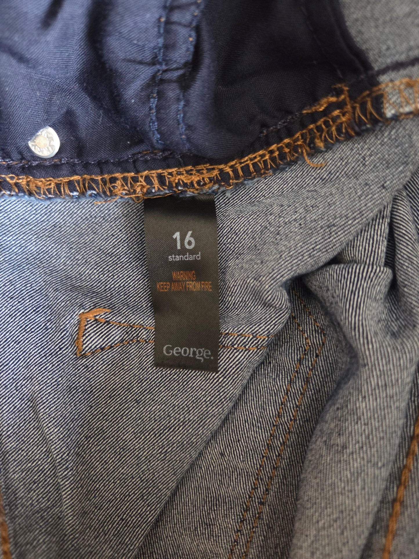 Close-up of a denim fabric with a brand label on a dark background