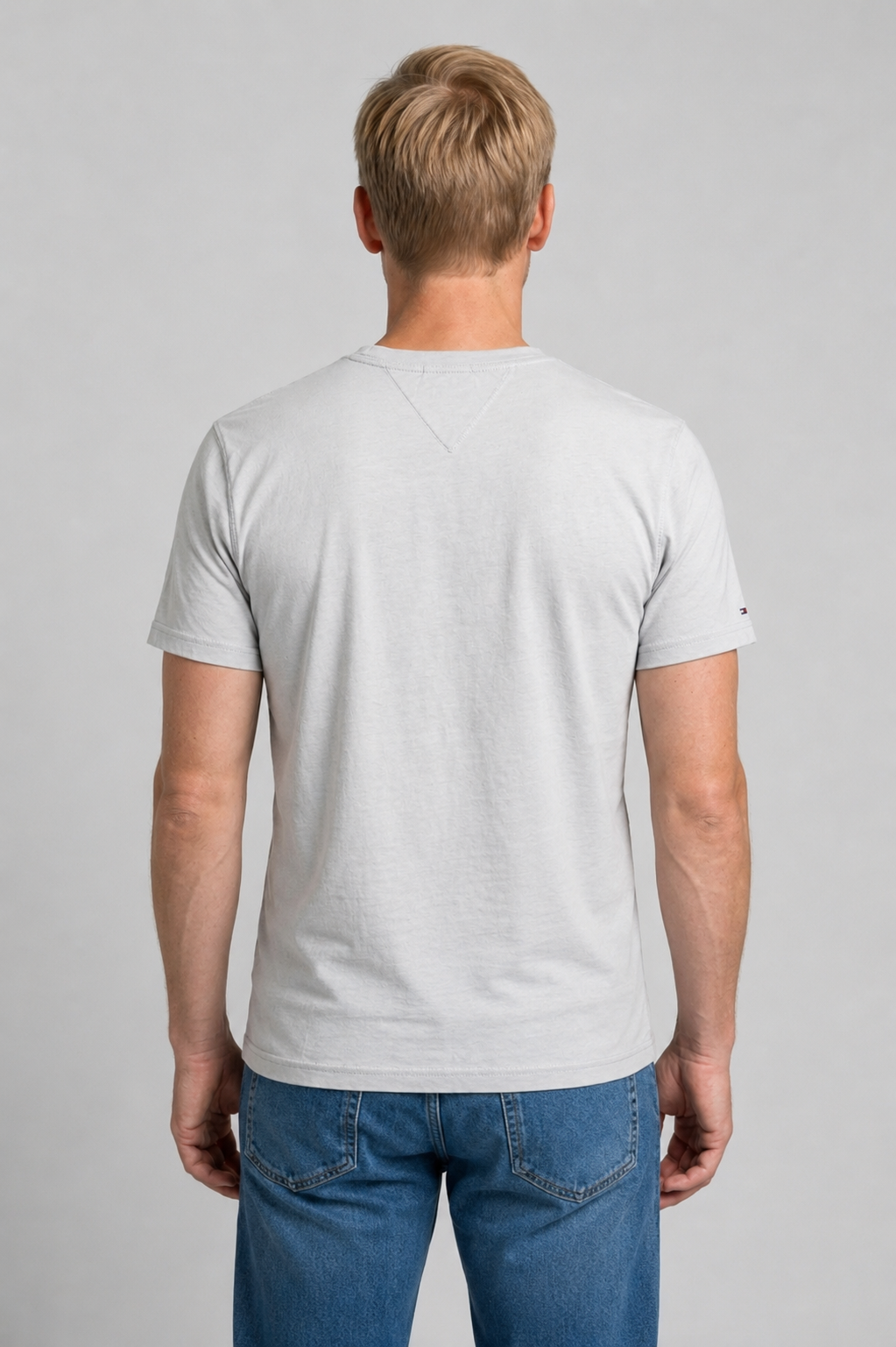 Man wearing a white t-shirt and blue jeans