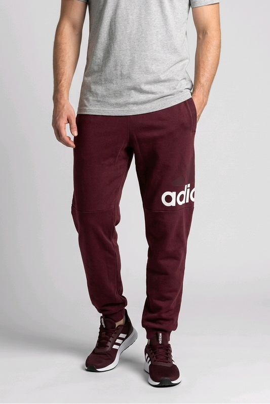 Man wearing a pair of burgundy Adidas Joggers