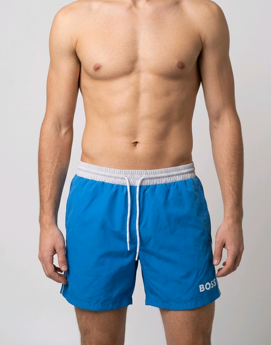 Man wearing blue swim shorts with a white drawstring and 'BOSS' branding 