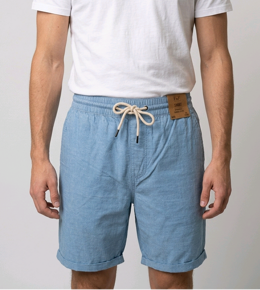 Man wearing light blue shorts with a white t shirt