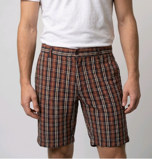 Man wearing a white t-shirt and plaid shorts 