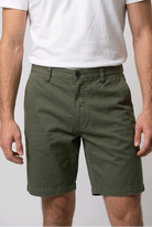 Man wearing a white t shirt and a pair of green chino shorts