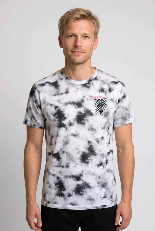 Man wearing a tie-dye t-shirt with a palm tree design 